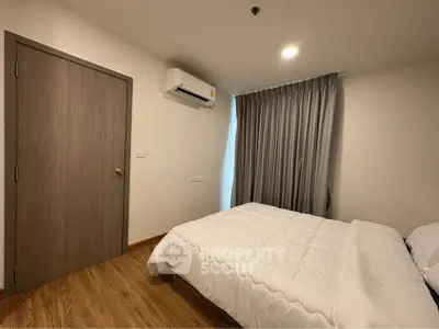 Cozy bedroom with modern decor and air conditioning, perfect for relaxation.