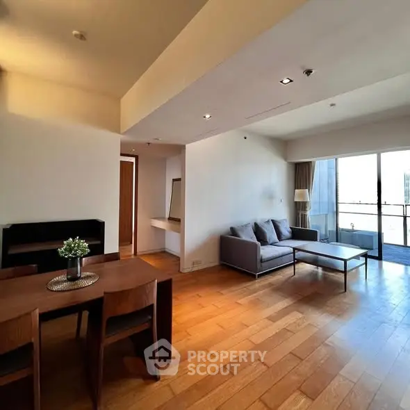 Spacious modern living room with wooden flooring and balcony view