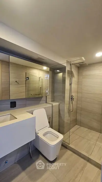 Modern bathroom with sleek design, featuring a glass shower and contemporary fixtures.