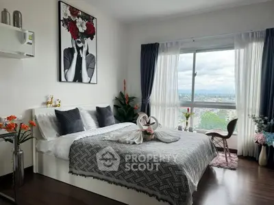 Stylish bedroom with large window offering stunning city view and elegant decor.