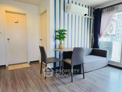 Modern living room with stylish decor and balcony view, featuring sleek furniture and air conditioning.