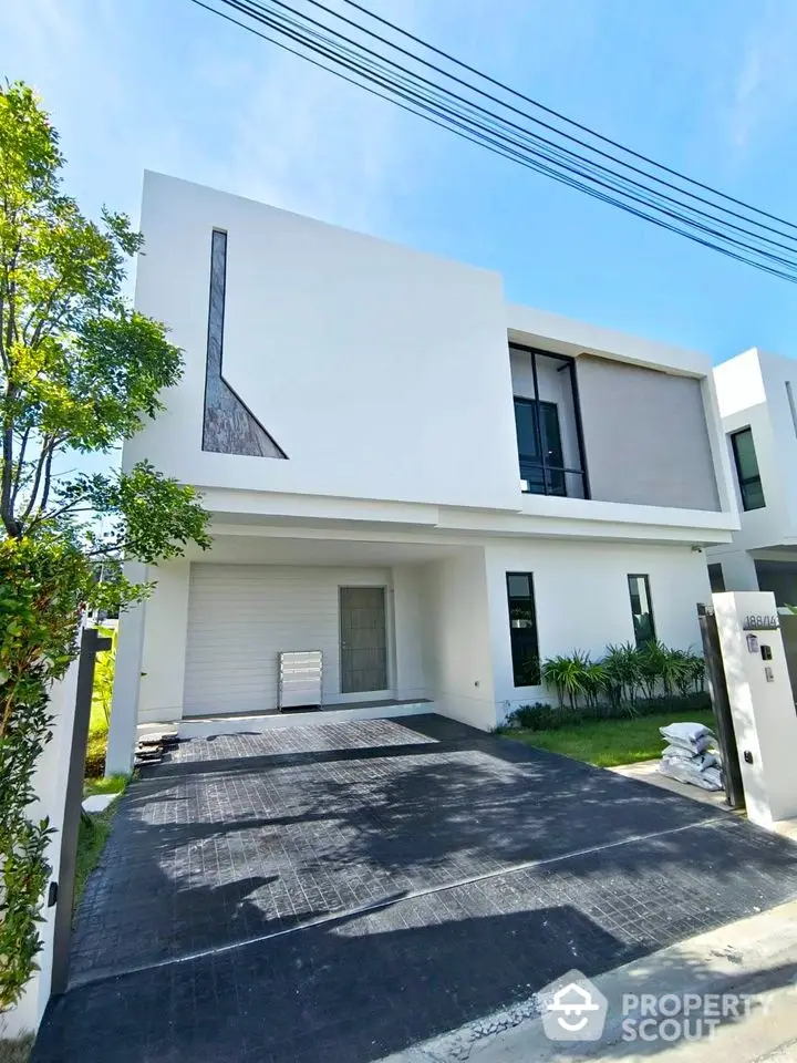 Modern minimalist two-story house with sleek facade and spacious driveway