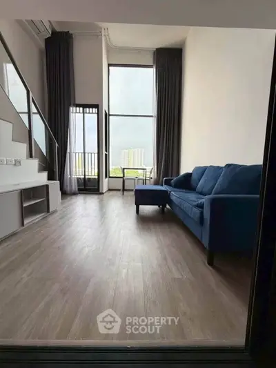 Spacious modern living room with high ceilings and large windows offering stunning city views.