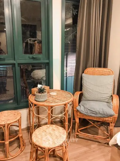 Cozy corner with wicker furniture and large window in stylish living room.