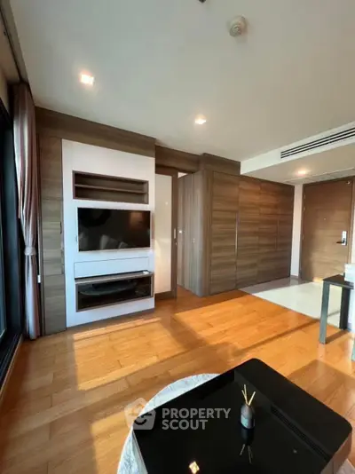 Modern living room with wooden flooring and built-in TV unit