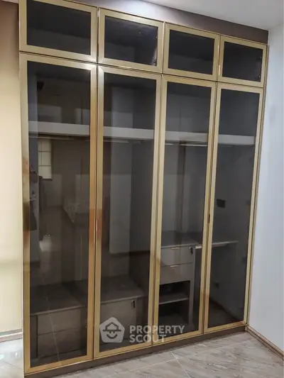 Spacious built-in wardrobe with glass doors in modern bedroom