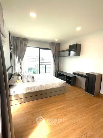 Bright and spacious bedroom with modern furnishings and large window view.