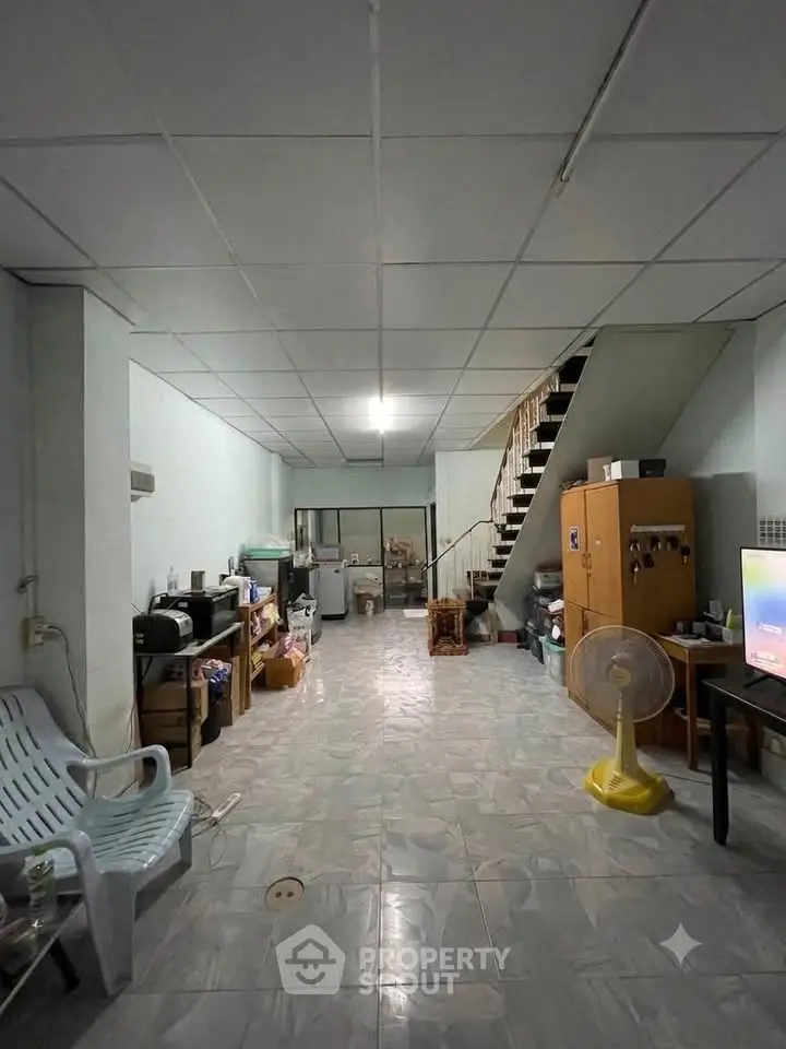 Spacious living room with staircase and tiled flooring in a modern home
