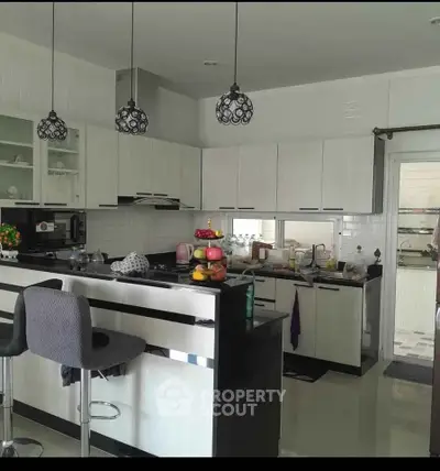 Modern kitchen with sleek white cabinets and stylish pendant lighting