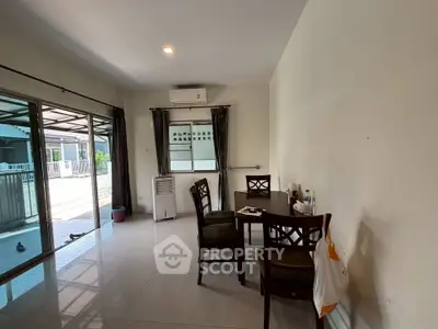 Spacious living room with sliding glass doors leading to a balcony, featuring modern furniture and ample natural light.