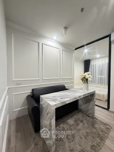Modern living room with marble table and black sofa, elegant decor and cozy ambiance.