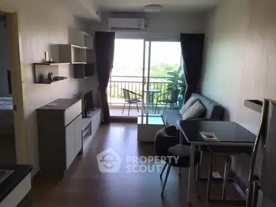 Modern living room with balcony view, featuring sleek furniture and natural light.