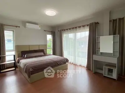 Spacious bedroom with modern decor and large windows for natural light