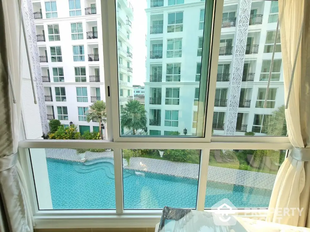 Stunning view of modern apartment complex with pool from window