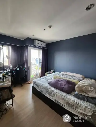 Spacious bedroom with modern design, featuring a large bed, elegant dark curtains, and access to a sunlit balcony with a view.