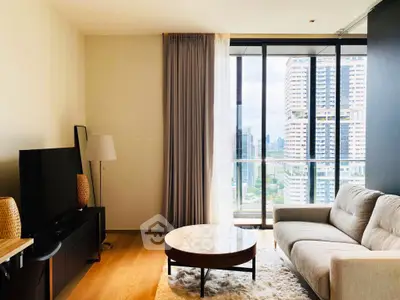 Modern living room with city view, featuring a cozy sofa, TV, and elegant decor.