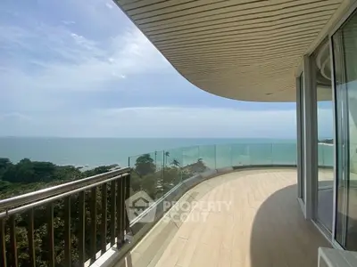 Stunning beachfront balcony with panoramic ocean views and modern glass railing.
