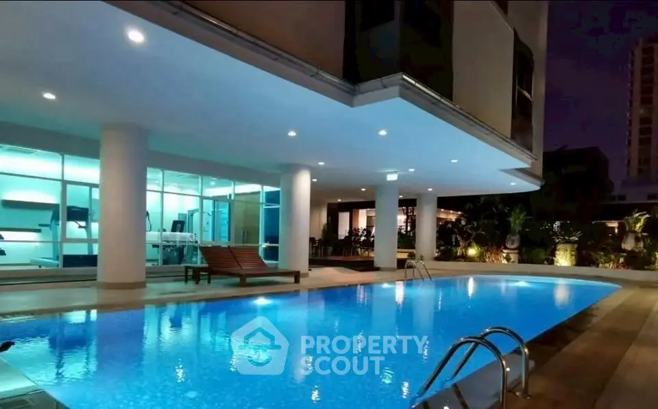 Luxurious night view of a modern apartment pool area with ambient lighting.