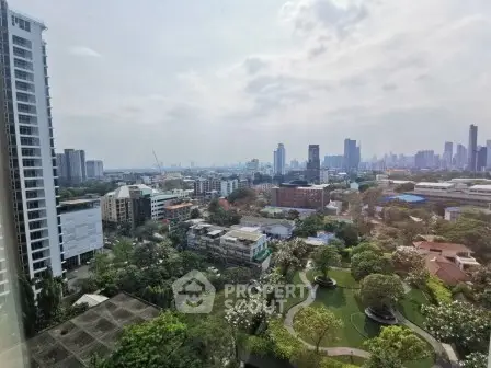 Stunning cityscape view from high-rise apartment overlooking lush greenery and urban skyline.