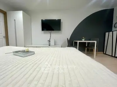 Modern bedroom with sleek decor and wall-mounted TV