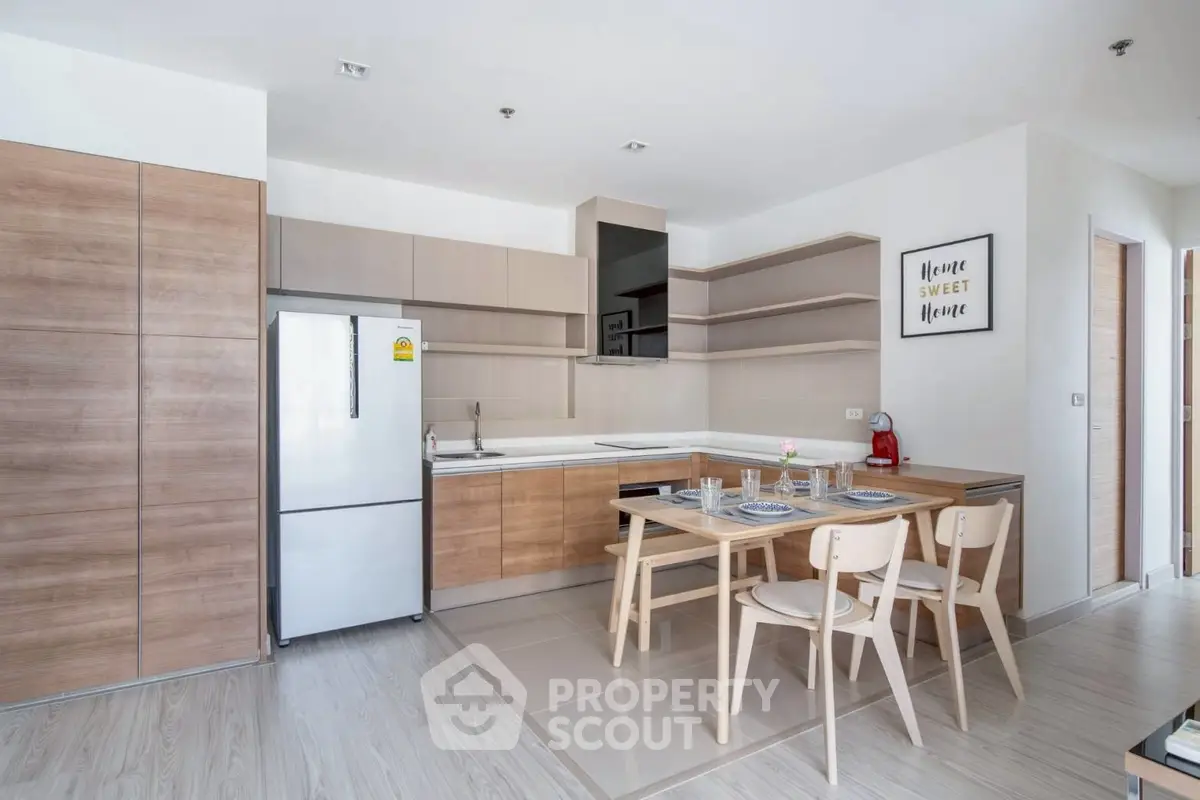 Modern kitchen with sleek wooden cabinets and dining area in stylish apartment.