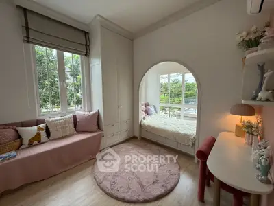 Charming children's bedroom with cozy window nook and elegant decor