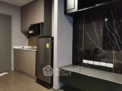 Modern kitchen with sleek cabinetry and compact fridge in stylish apartment