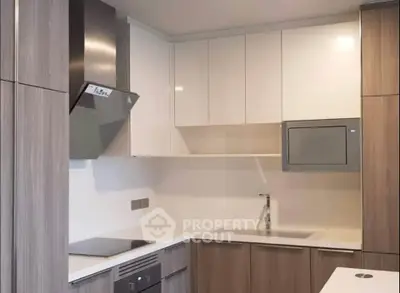 Modern kitchen with sleek cabinetry and built-in appliances in a stylish apartment.