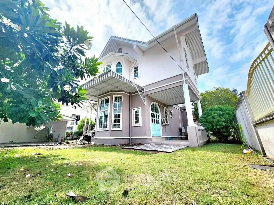 Charming two-story house with lush garden and spacious lawn, perfect for family living.