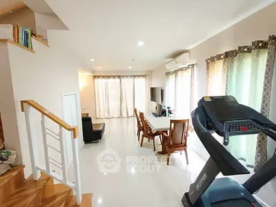 Spacious living room with treadmill and elegant dining area, perfect for modern family living.