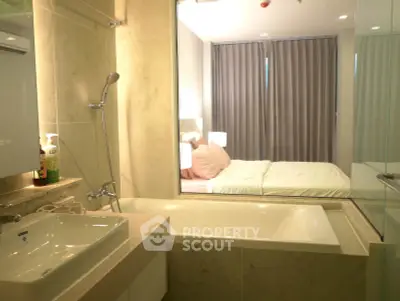 Modern bathroom with bathtub and view into cozy bedroom