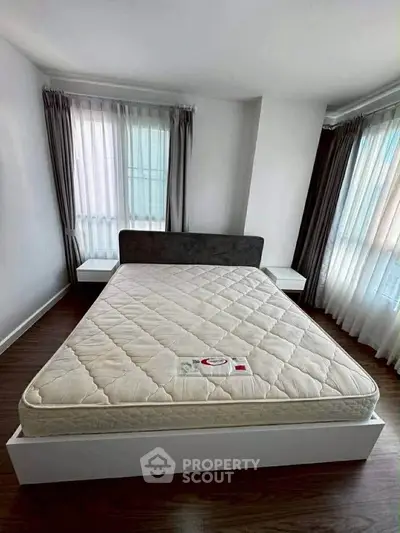 Spacious bedroom with large windows and modern bed frame, perfect for natural light lovers.