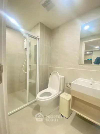 Modern bathroom with glass shower and sleek fixtures in a contemporary home.