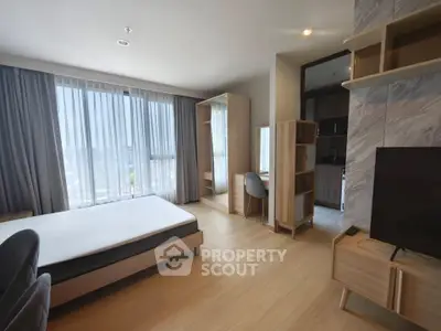 Spacious modern bedroom with natural light and elegant furnishings in a stylish apartment.