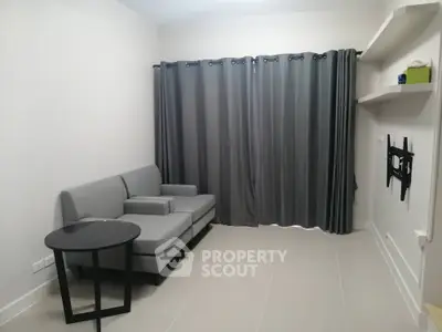 Modern minimalist living room with sleek grey sectional sofa, black coffee table, and elegant dark curtains, perfect for urban living.