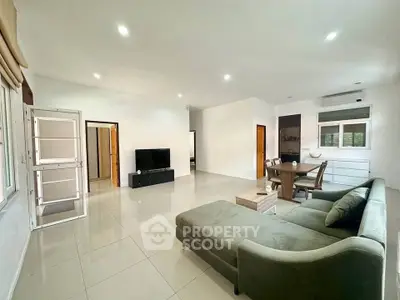 Spacious modern living room with sleek furniture and ample natural light, perfect for relaxation and entertainment.