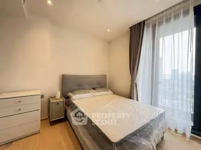 Modern bedroom with large window and elegant curtains in a stylish apartment.