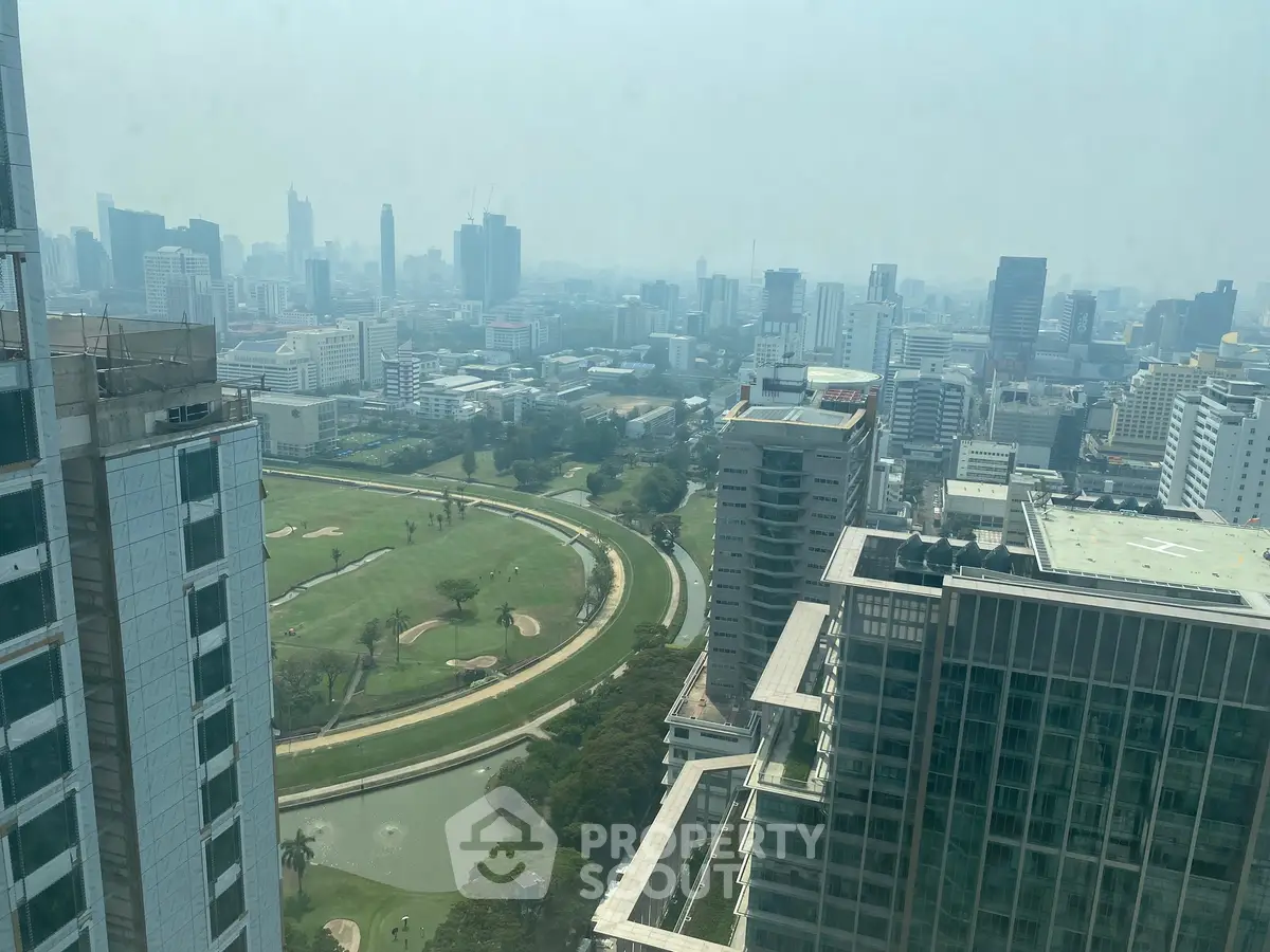 Stunning cityscape view from high-rise building overlooking lush golf course and skyline.