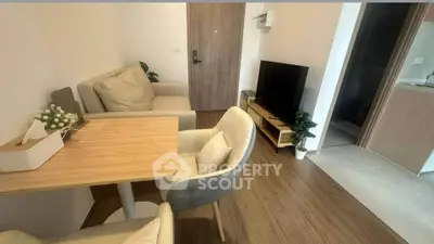 Cozy living room with modern furniture and TV, perfect for relaxation.