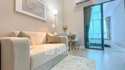 Modern living room with cozy sofa and stylish decor adjacent to a bright bedroom.
