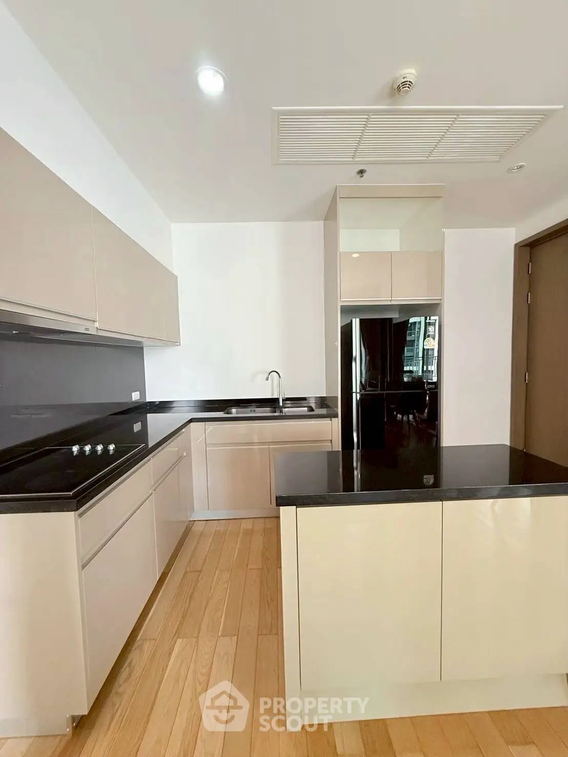 Modern kitchen with sleek cabinetry and black countertops in a stylish apartment.