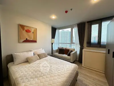 Modern bedroom with city view and cozy seating area