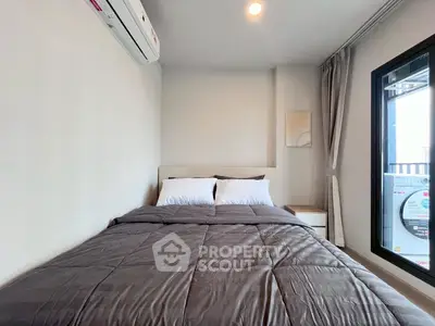 Cozy bedroom with modern decor and large window for natural light.