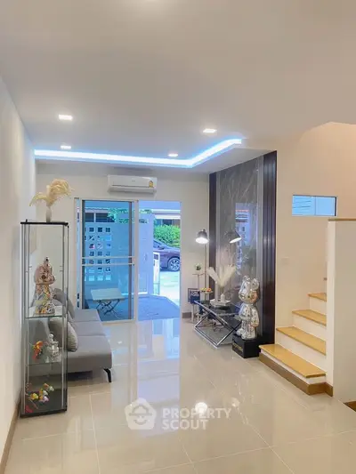 Modern living room with sleek design, glass display cabinets, and stylish decor in a bright, airy space.