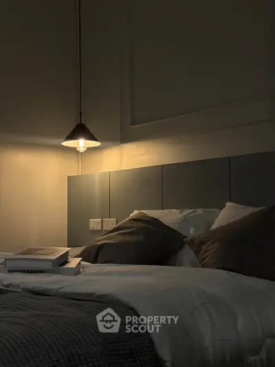Cozy bedroom with modern lighting and plush bedding, perfect for relaxation.