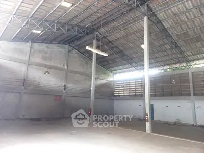 Spacious industrial warehouse with high ceilings and ample natural light, perfect for storage or manufacturing.