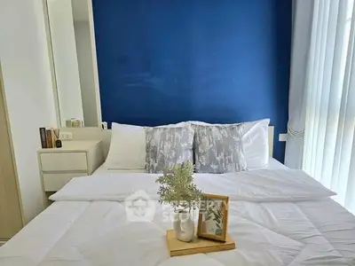 Modern bedroom with stylish blue accent wall and cozy bedding