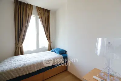 Cozy bedroom with natural light and elegant curtains, perfect for relaxation.