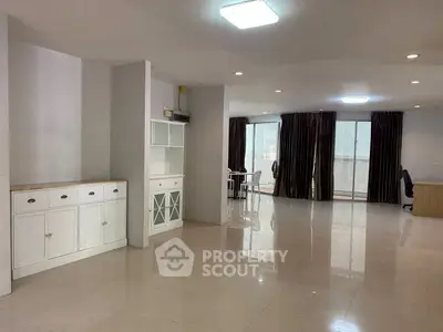 Spacious open-plan living room with modern decor and ample natural light.