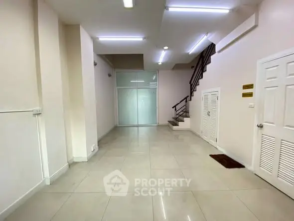 Spacious interior with modern staircase and tiled flooring